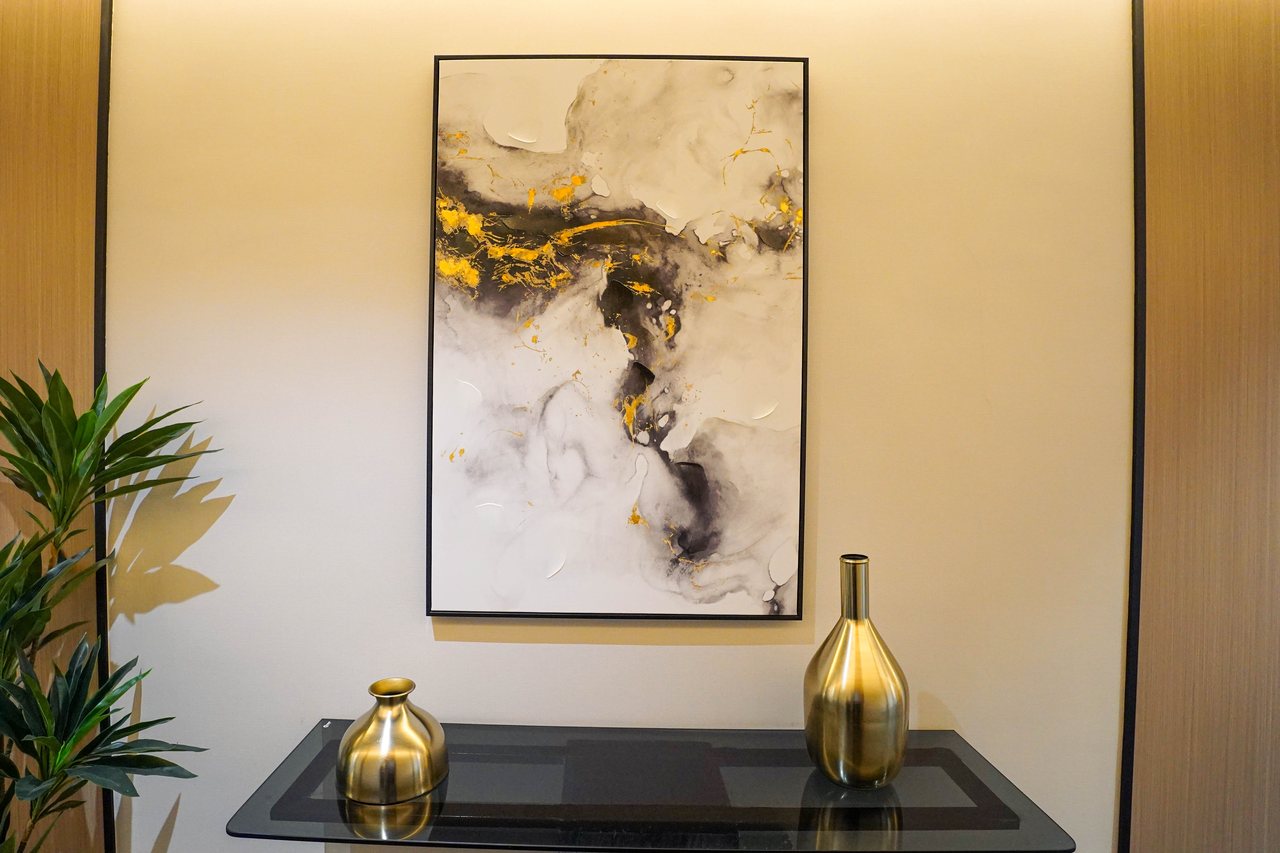 Corridor console with abstract artwork and brass vessels in a Business Square office floor