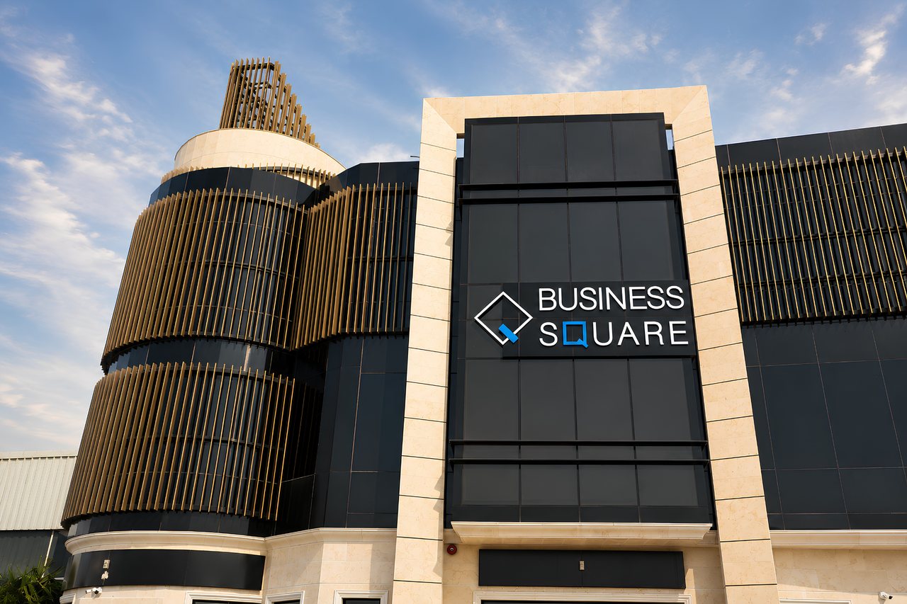Business Square illuminated signage set into the dark glass elevation above the main entrance