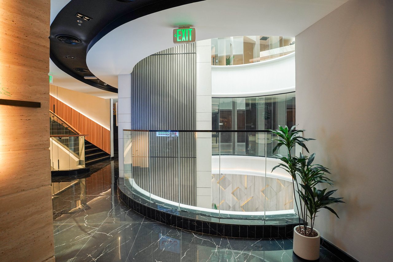 Curved ceiling reveal and fluted glass wrapping the Business Square atrium