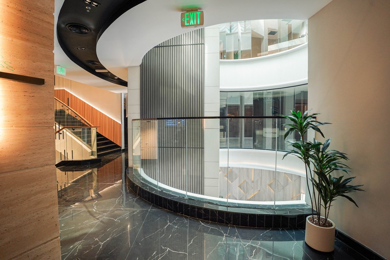 Atrium void with fluted glass, planting and the curved ceiling detail above
