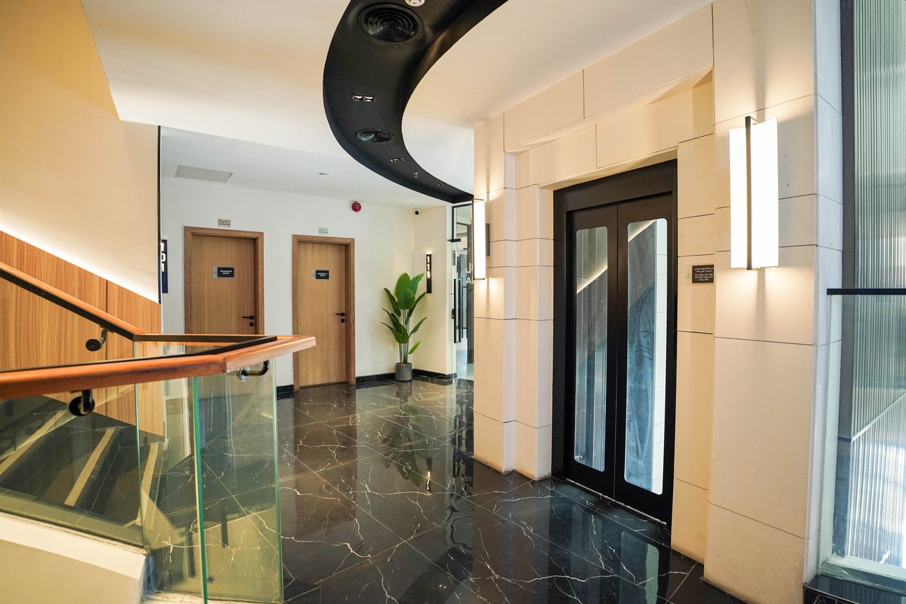 Junction between the floor lobby and office corridor with warm cove lighting