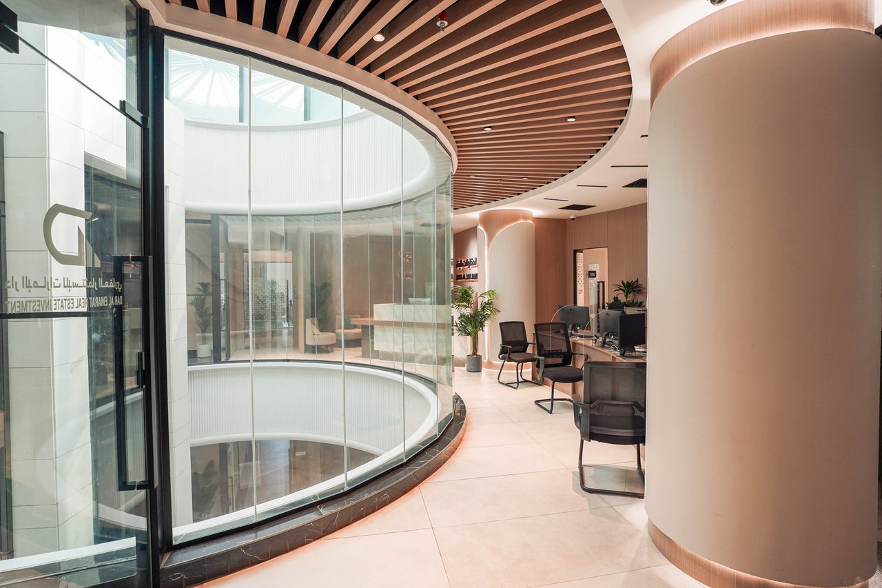 Glass lift shaft and seating area under the timber slat ceiling of the main lobby