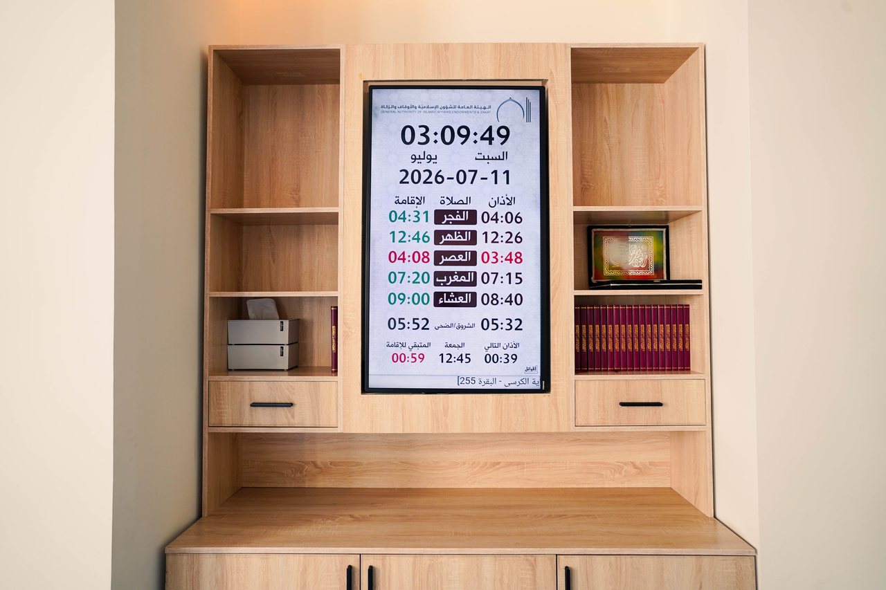Prayer-time display and bookshelf unit in the Business Square prayer hall