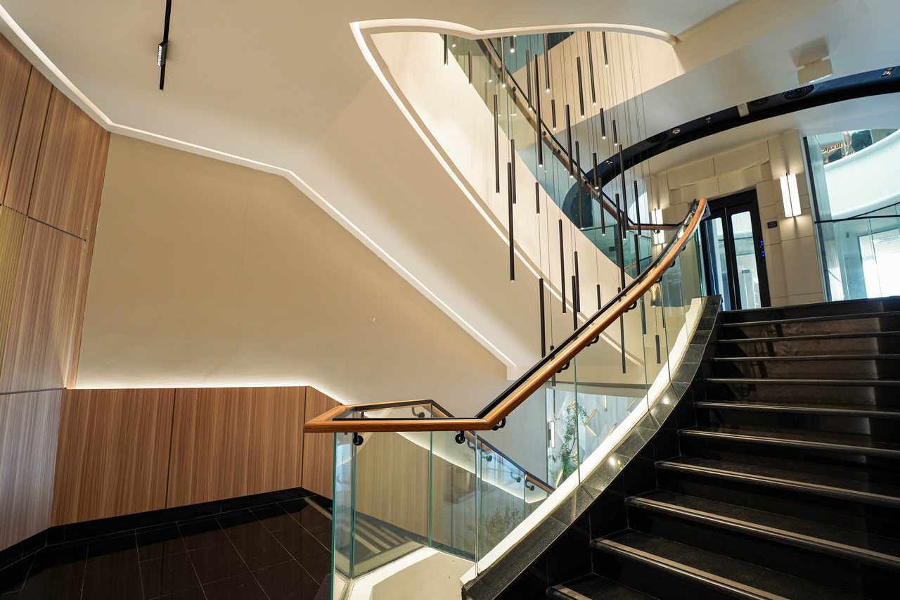 Chandelier rods above the polished stair treads and glass balustrade
