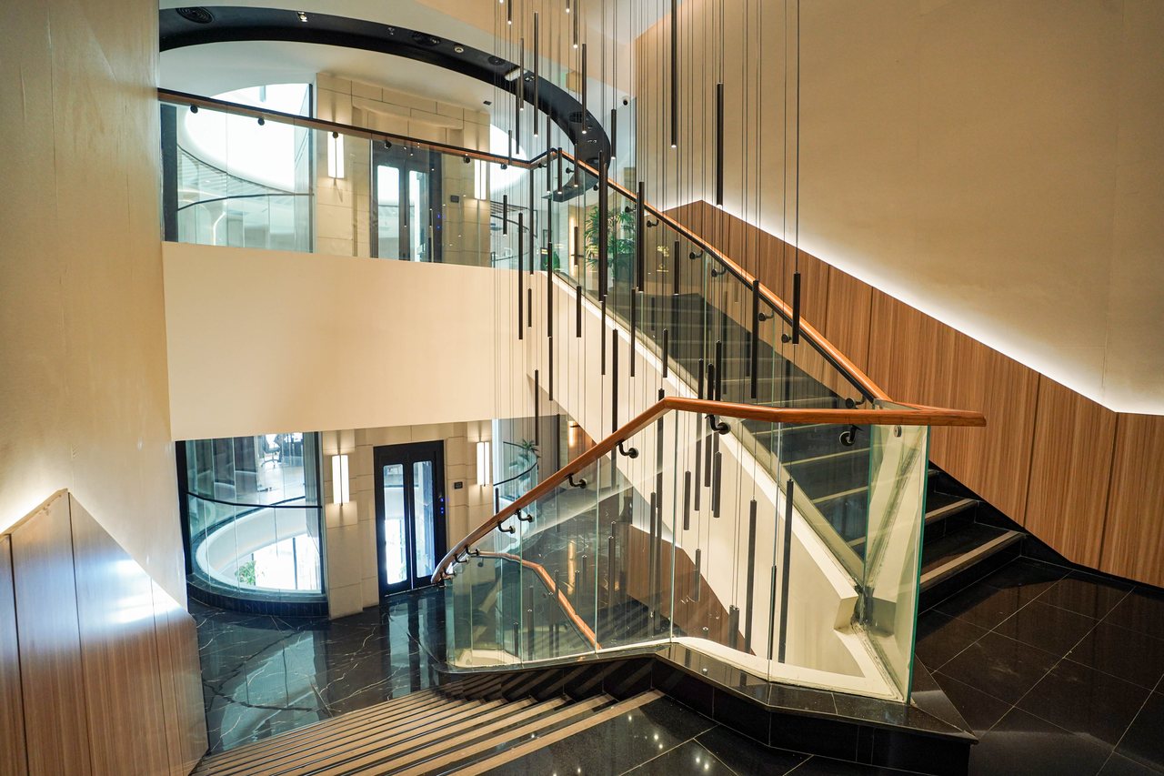 Stair flight and chandelier rods above the polished black treads